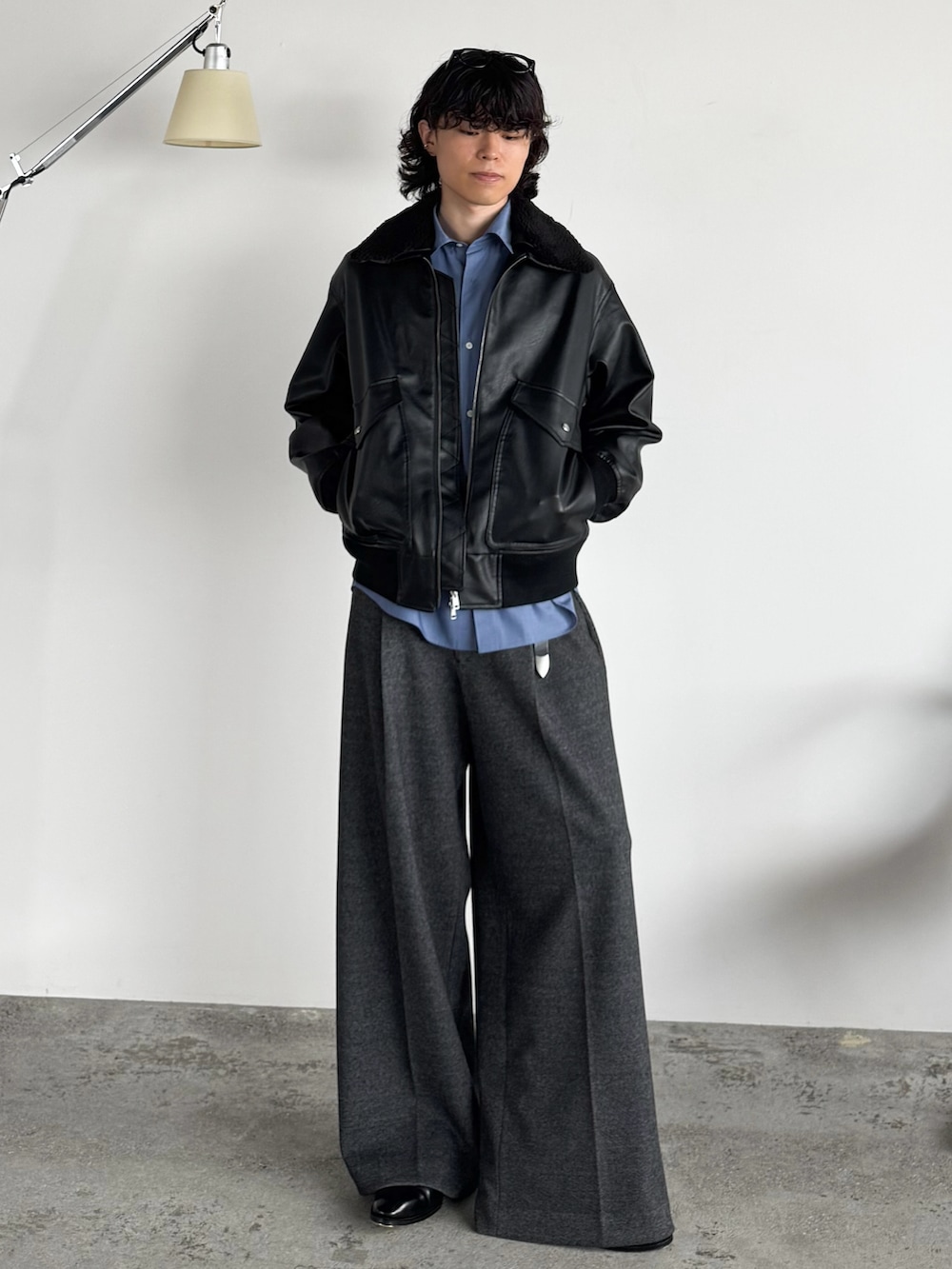 ブラック系のブルゾン、ブルー系のシャツ/ブラウス、グレー系のスラックスを着用したメンズの秋コーディネートの3枚目の写真