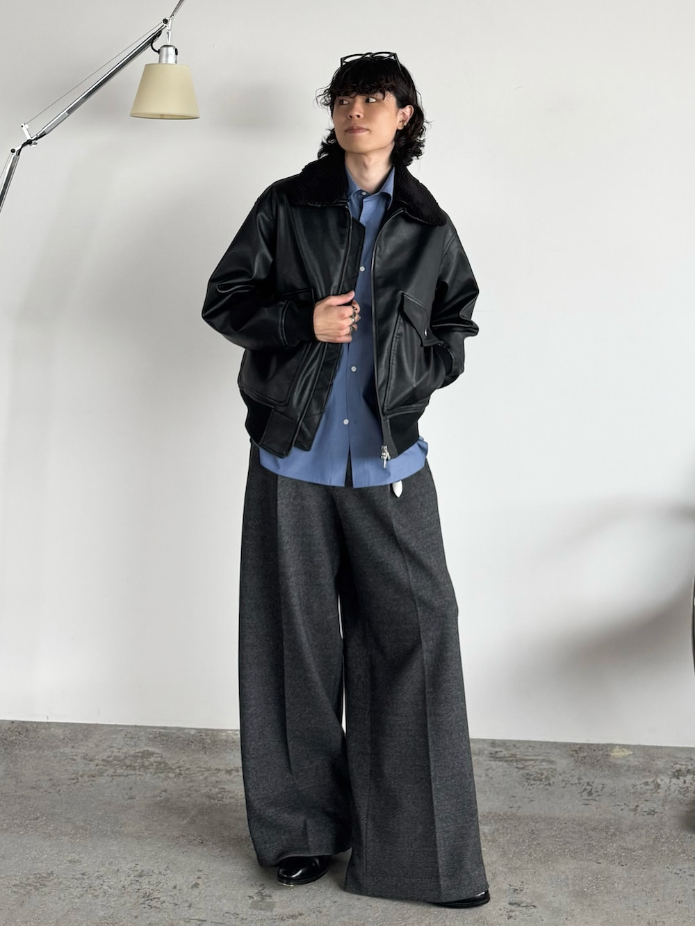 ブラック系のブルゾン、ブルー系のシャツ/ブラウス、グレー系のスラックスを着用したメンズの秋コーディネートの2枚目の写真