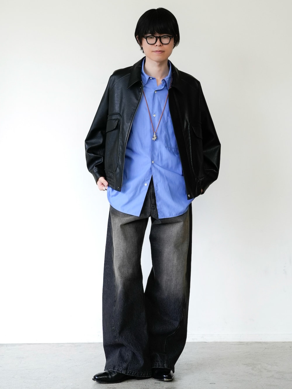 ブラック系のブルゾン、ブラック系のデニムパンツ、ブルー系のシャツ/ブラウスを着用したメンズの春コーディネートの3枚目の写真