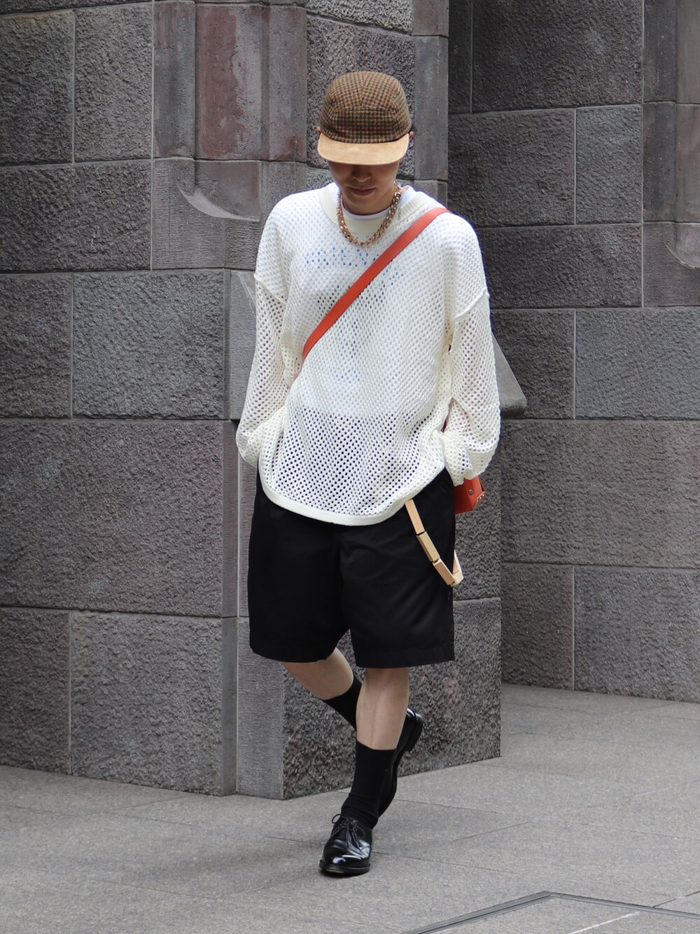 オレンジ系のショルダーバッグ、ホワイト系のニット/セーター、ブラック系のチノパンツを着用したメンズの夏コーディネートの4枚目の写真