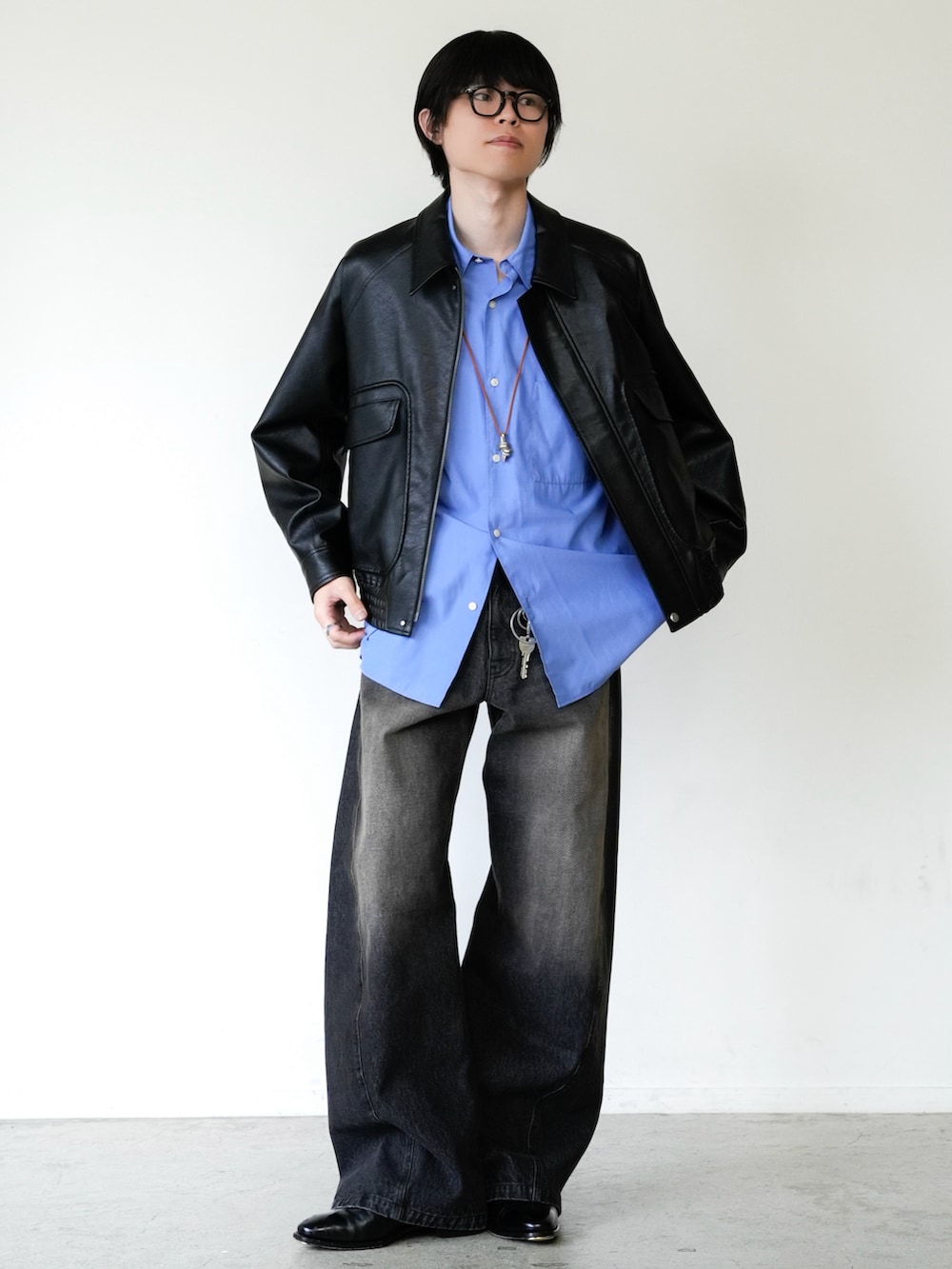 ブラック系のブルゾン、ブラック系のデニムパンツ、ブルー系のシャツ/ブラウスを着用したメンズの春コーディネートの2枚目の写真