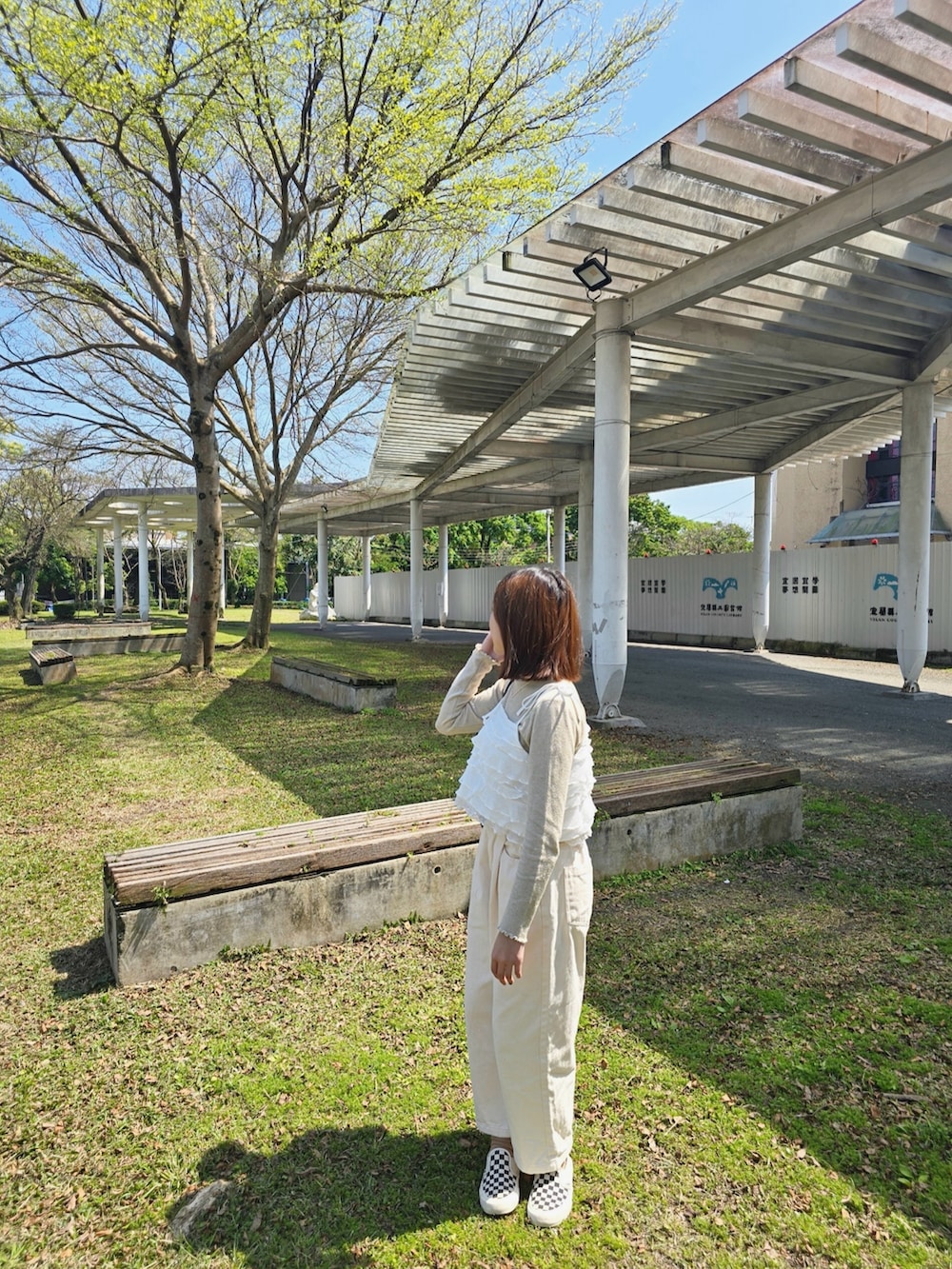 ホワイト系のキャミソール、ベージュ系のチノパンツ、ホワイト系のスリッポンを着用したレディースの春コーディネートの2枚目の写真