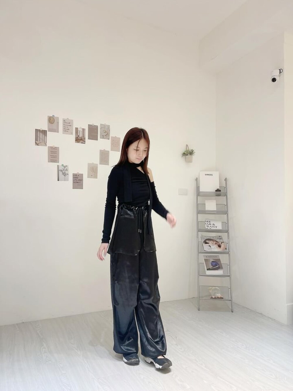 ブラック系のトップス、ブラック系のチノパンツ、ブラック系のサンダルを着用したレディースの春コーディネートの2枚目の写真