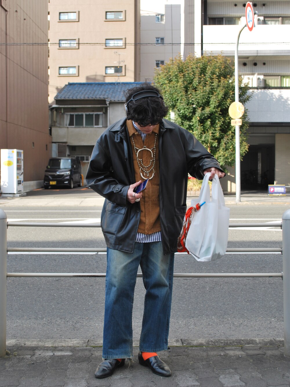 ホワイト系のバッグ、ブルー系のデニムパンツ、ブラック系のジャケット/アウターを着用したメンズの春コーディネートの2枚目の写真