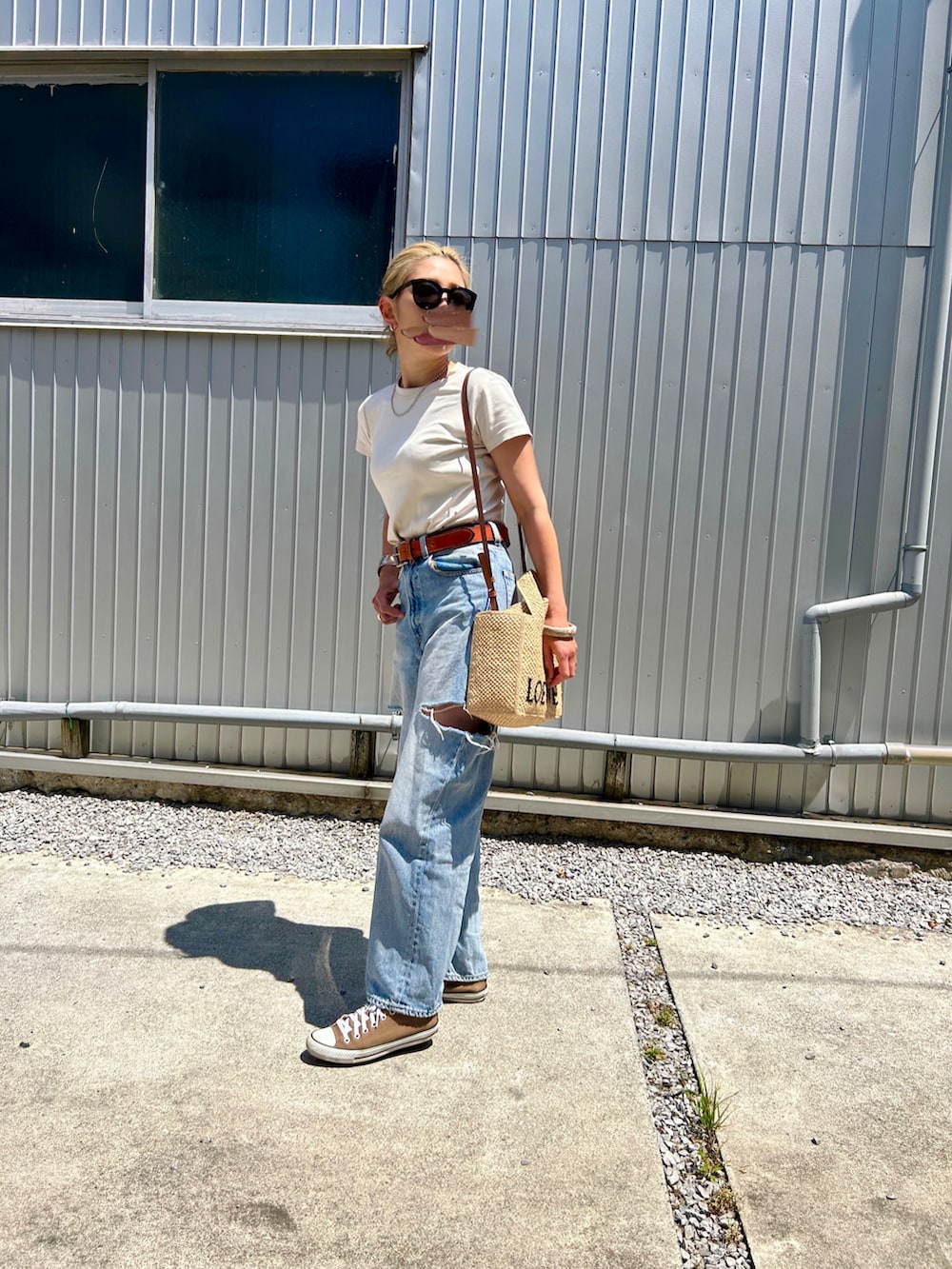 ホワイト系のTシャツ/カットソー、ブルー系のデニムパンツ、ベージュ系のかごバッグを着用したレディースの春コーディネートの2枚目の写真