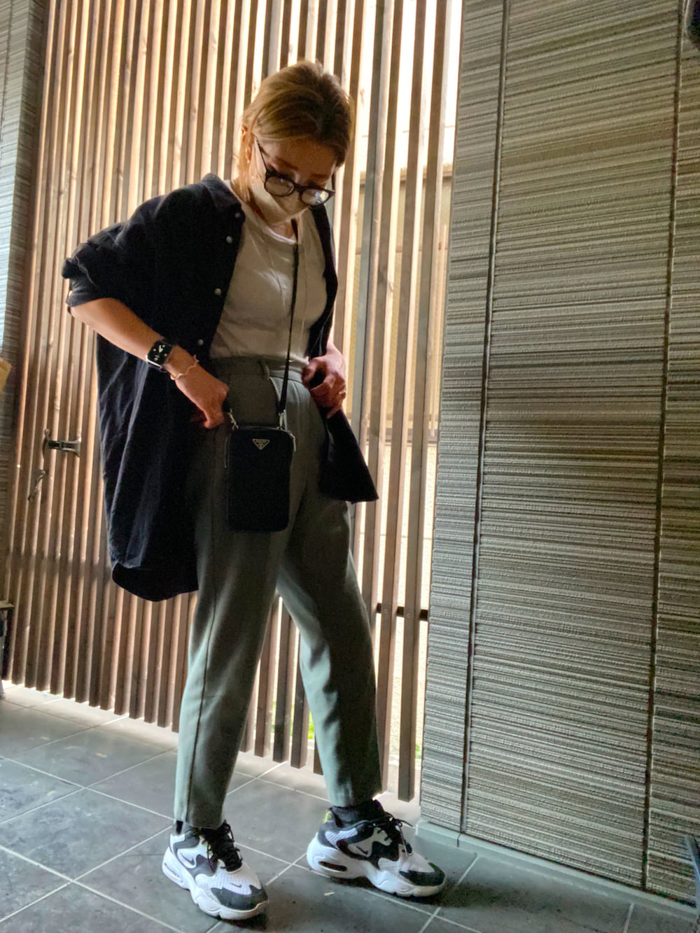 グレー系のTシャツ/カットソー、ブラック系のシャツ/ブラウス、ホワイト系のスニーカーを着用したレディースの春コーディネートの2枚目の写真