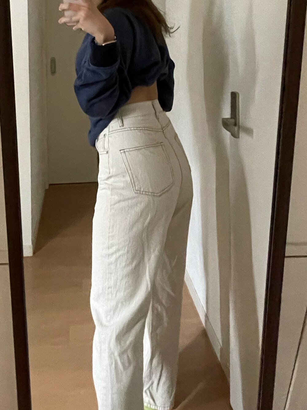 ブルー系のスウェット、ホワイト系のデニムパンツを着用したレディースの夏コーディネートの3枚目の写真