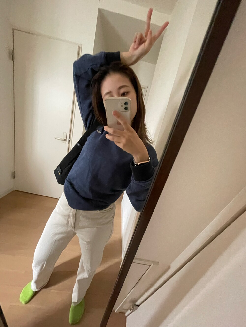 ブルー系のスウェット、ホワイト系のデニムパンツを着用したレディースの夏コーディネートの2枚目の写真