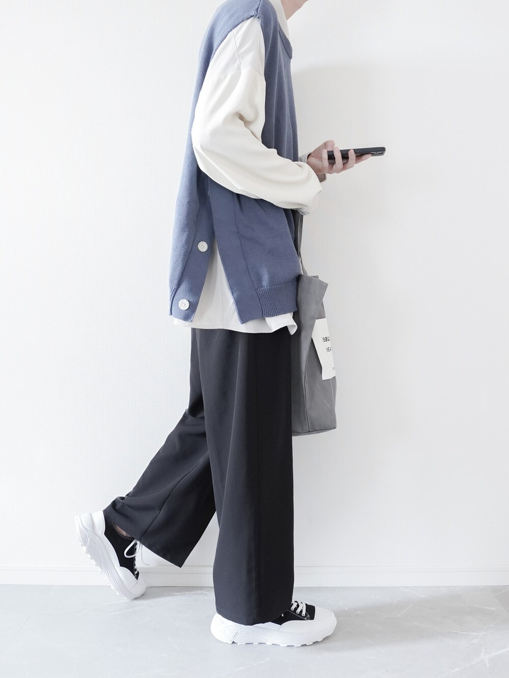 ブルー系のベスト、ホワイト系のシャツ/ブラウス、ブラック系のスラックスを着用したメンズの春コーディネートの2枚目の写真