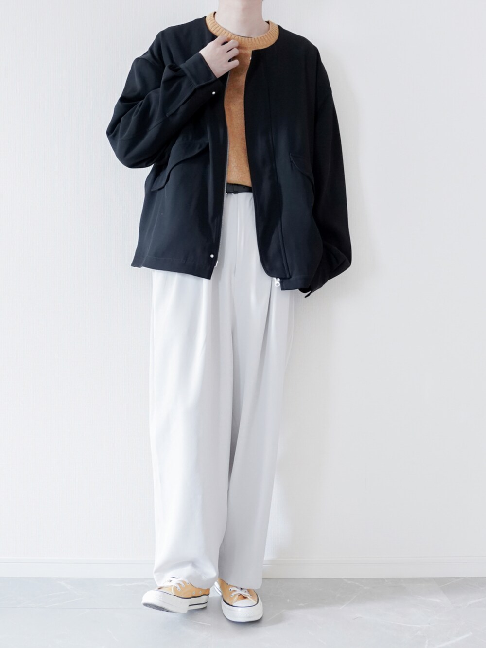 ブラック系のMA-1、イエロー系のニット/セーター、グレー系のその他パンツを着用したメンズの春コーディネートの2枚目の写真