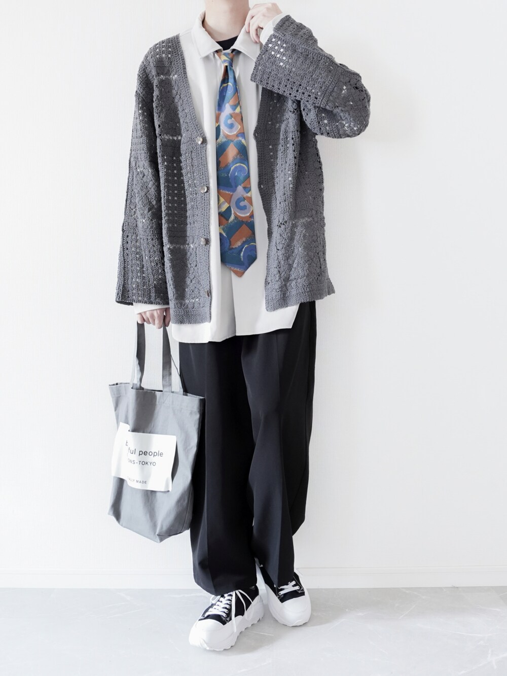 グレー系のカーディガン/ボレロ、ホワイト系のシャツ/ブラウス、ブラック系のスラックスを着用したメンズの春コーディネートの2枚目の写真