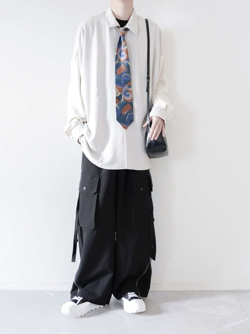 ホワイト系のシャツ/ブラウス、ブラック系のカーゴパンツ、ブラック系のスニーカーを着用したメンズの春コーディネートの2枚目の写真