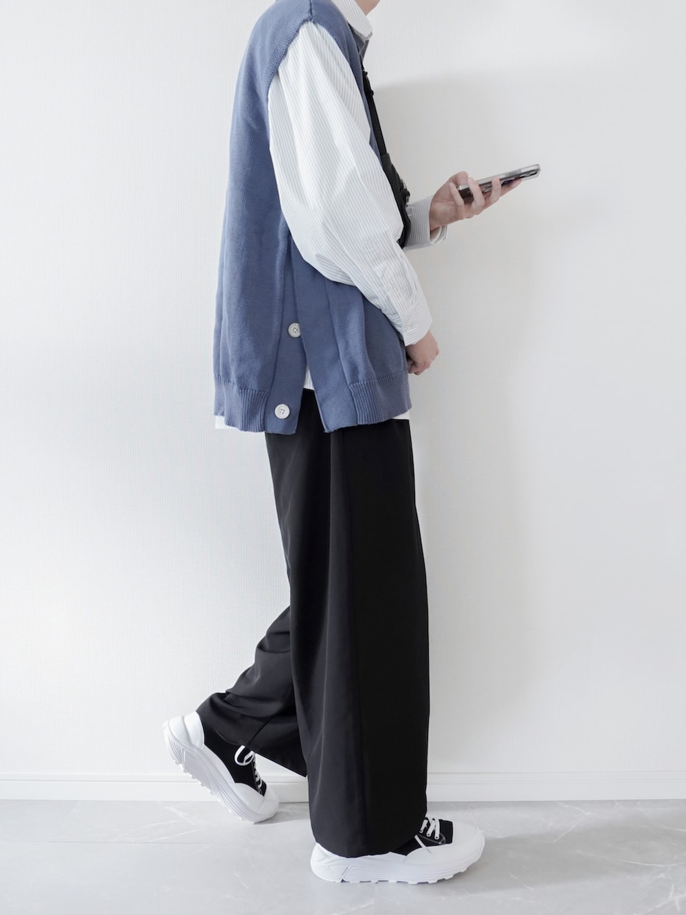 ブルー系のベスト、ホワイト系のシャツ/ブラウス、ブラック系のスラックスを着用したメンズの春コーディネートの2枚目の写真