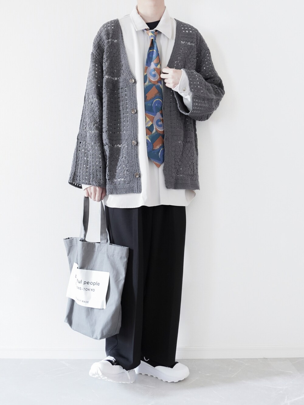 グレー系のカーディガン/ボレロ、ホワイト系のシャツ/ブラウス、ブラック系のスラックスを着用したメンズの春コーディネートの3枚目の写真