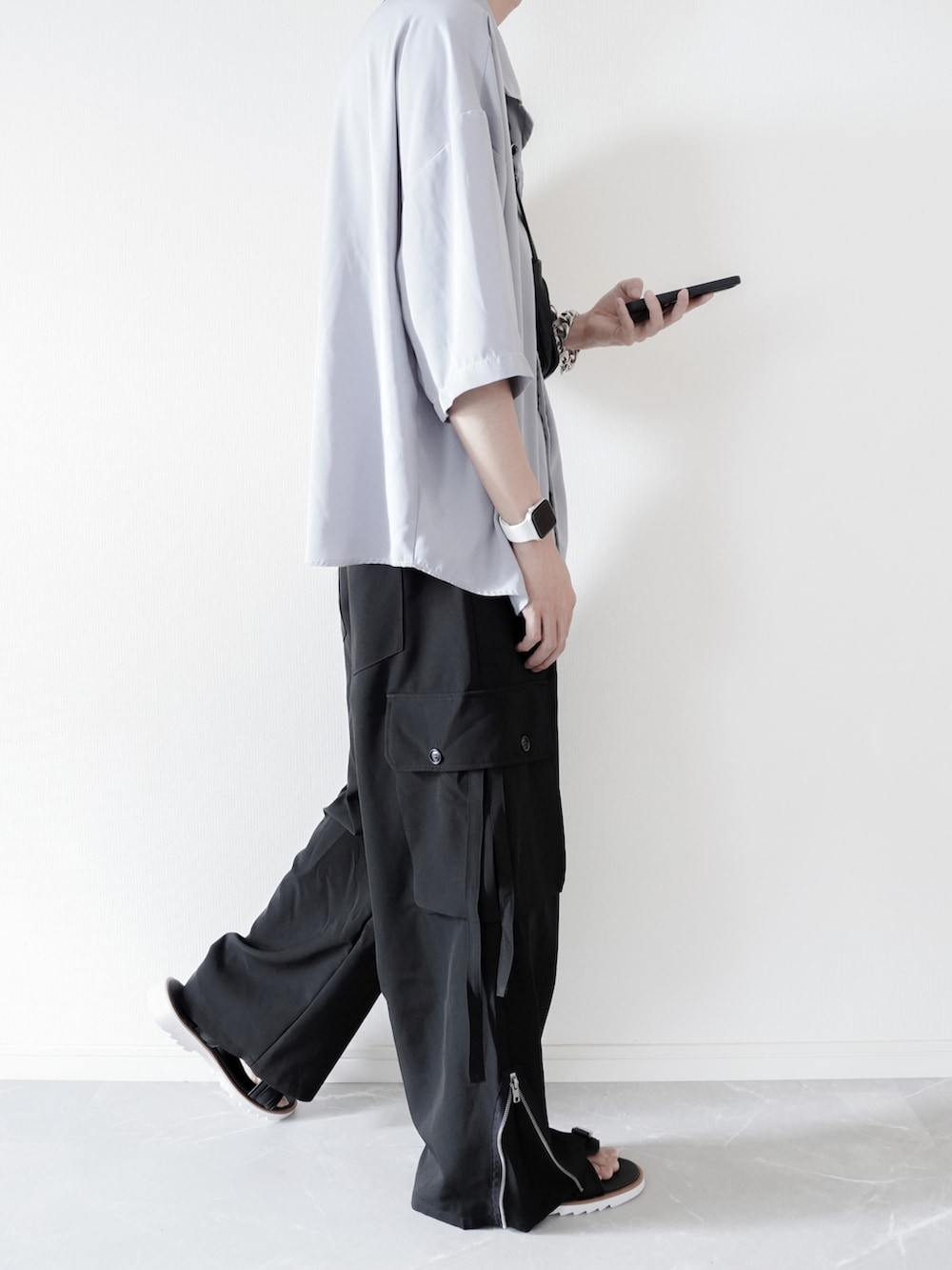 ブルー系のシャツ/ブラウス、ブラック系のカーゴパンツ、ホワイト系のサンダルを着用したメンズの夏コーディネートの3枚目の写真