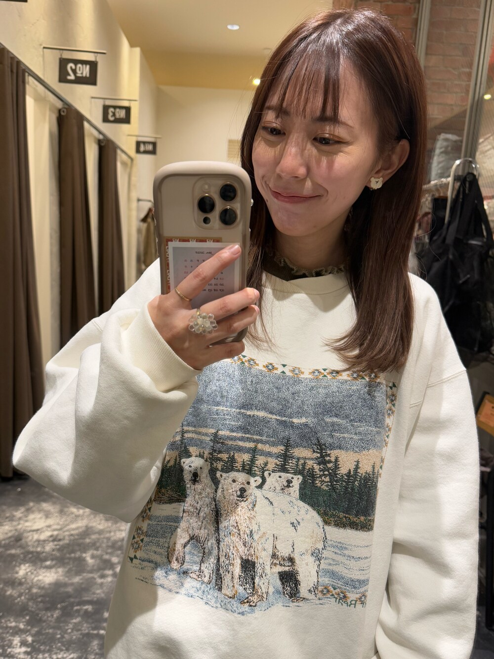 ホワイト系のスウェット、ブルー系のパンツ、ベージュ系のニット/セーターを着用したレディースの冬コーディネートの2枚目の写真