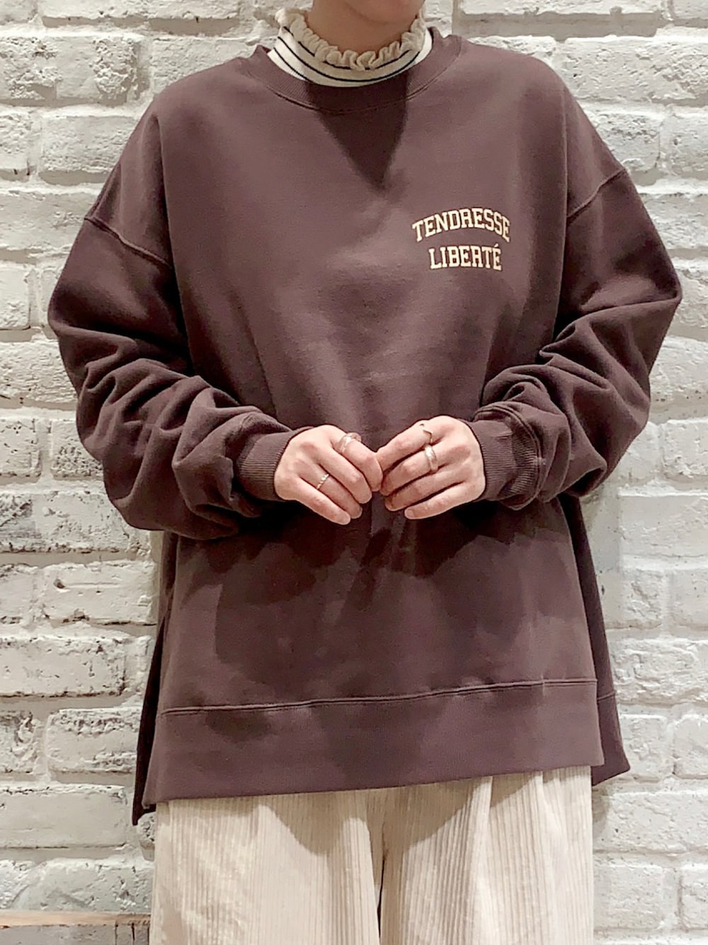 ホワイト系のニット/セーター、ブラウン系のTシャツ/カットソー、ホワイト系のその他パンツを着用したレディースの冬コーディネートの2枚目の写真