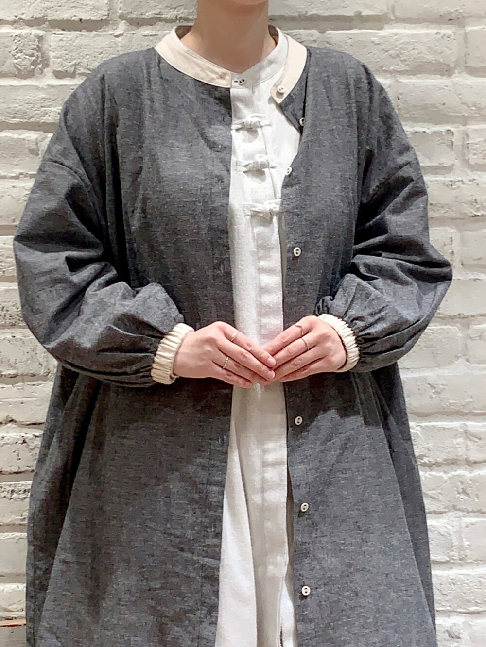 グレー系のワンピース、グレー系のチュニック、ホワイト系のその他パンツを着用したレディースの春コーディネートの2枚目の写真