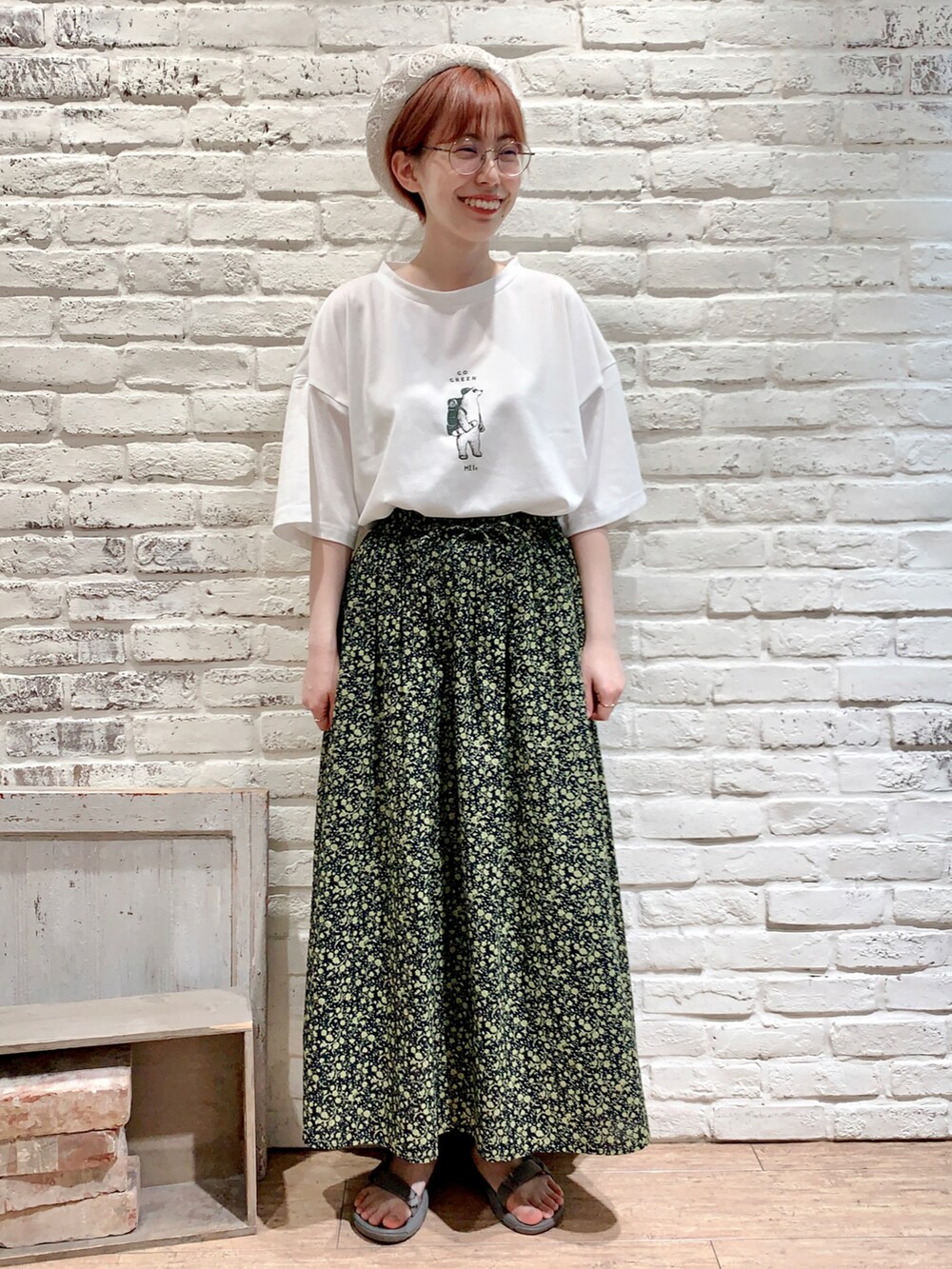ホワイト系のTシャツ/カットソー、グリーン系のベスト、ブラック系のスカートを着用したレディースの春コーディネートの4枚目の写真