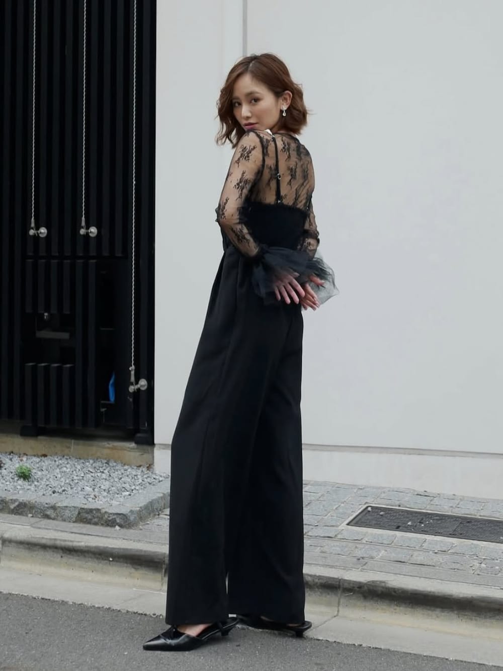 ブラック系のパンツドレスを着用したレディースの春コーディネートの2枚目の写真