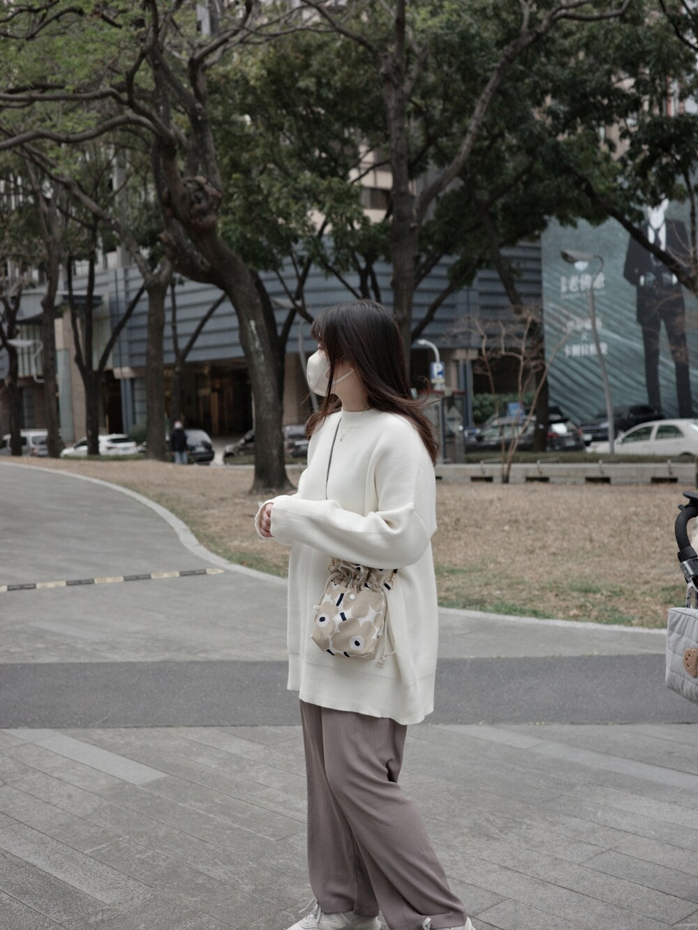 ホワイト系のニット/セーター、ブラウン系のチノパンツを着用したレディースの冬コーディネートの2枚目の写真