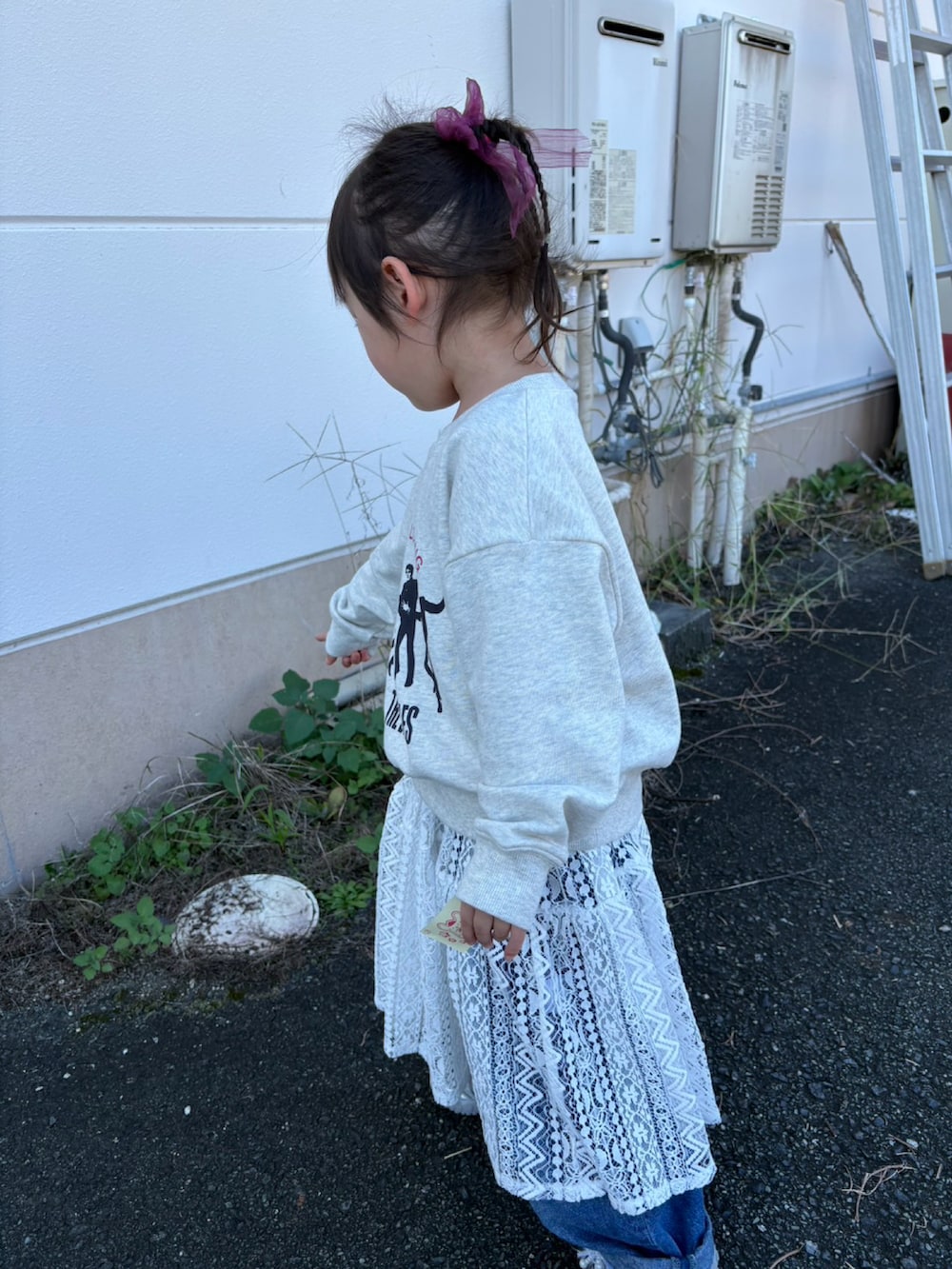 グレー系のスウェット、ホワイト系のチュニック、ブルー系のパンツを着用したレディースの秋コーディネートの3枚目の写真