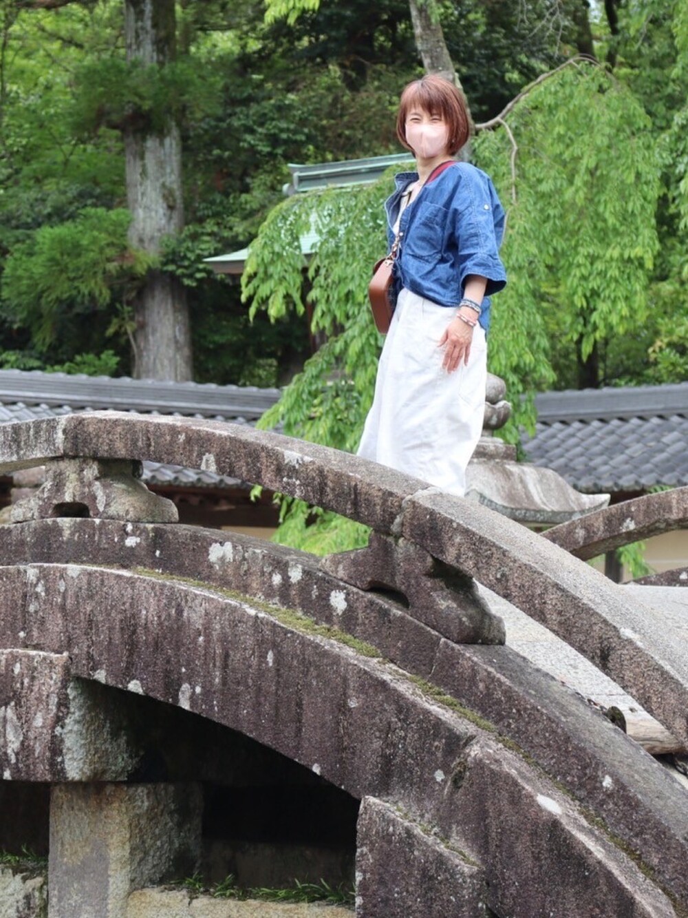 ブルー系のシャツ/ブラウス、レッド系のトップス、ホワイト系のデニムパンツを着用したレディースの夏コーディネートの3枚目の写真