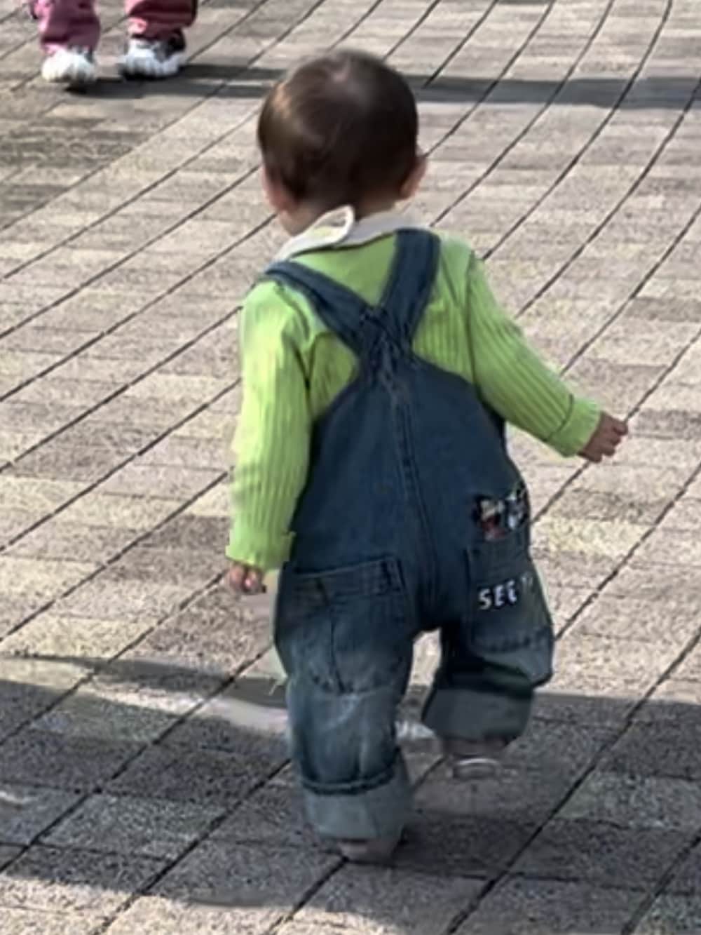 ホワイト系のスニーカー、ピンク系のその他パンツ、ブラック系のカーディガン/ボレロを着用したレディースの冬コーディネートの2枚目の写真