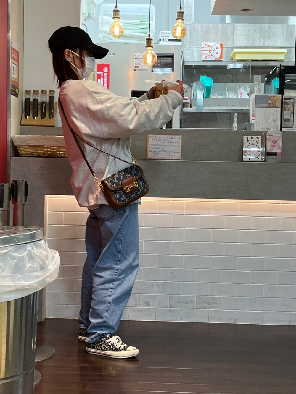 ブルー系のデニムパンツ、グレー系のスウェット、その他のスニーカーを着用したレディースの冬コーディネートの2枚目の写真