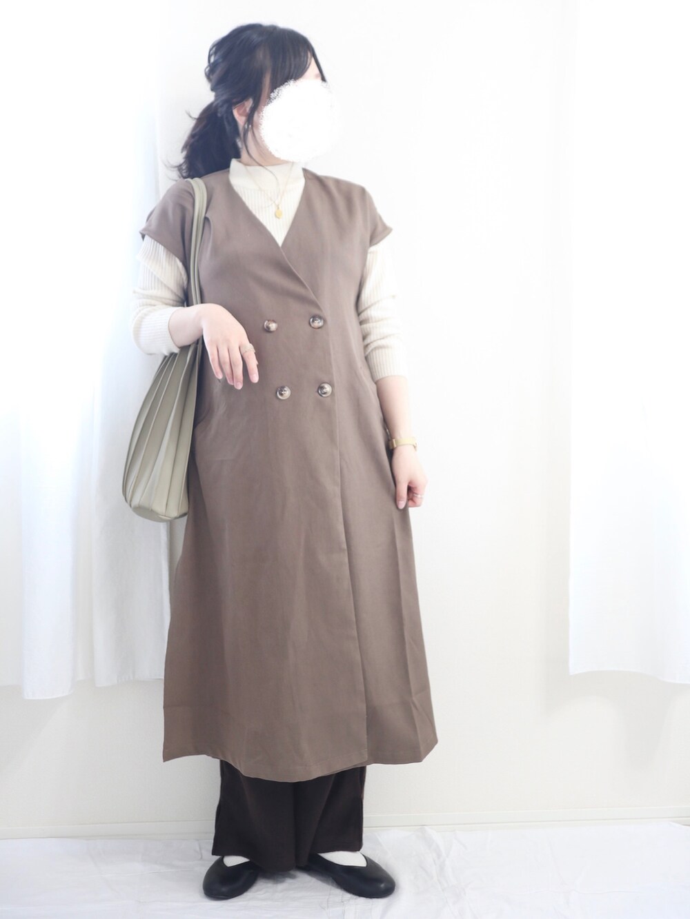 ホワイト系のニット/セーター、ブラウン系のワンピース、ブラウン系のパンツを着用したレディースの春コーディネートの2枚目の写真