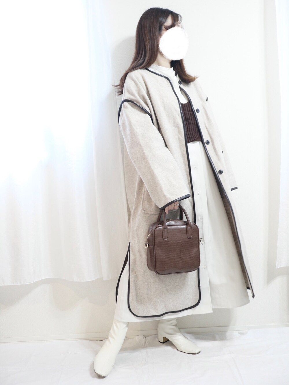 ホワイト系のシャツワンピース、ホワイト系のトートバッグ、ブラウン系のパンプスを着用したレディースの秋コーディネートの3枚目の写真