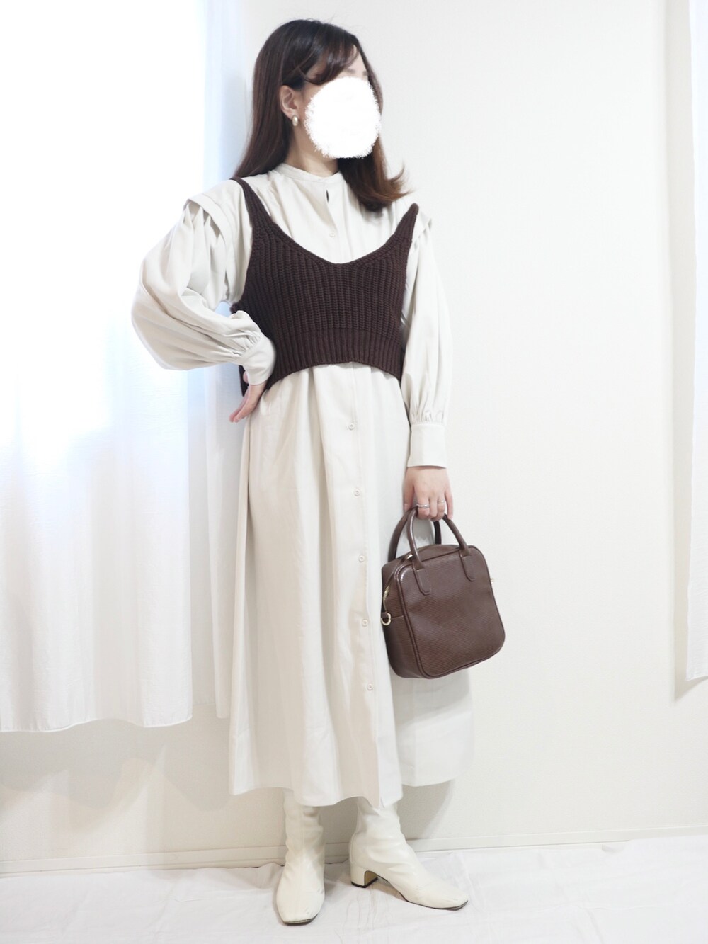 ホワイト系のシャツワンピース、ホワイト系のトートバッグ、ブラウン系のパンプスを着用したレディースの秋コーディネートの2枚目の写真