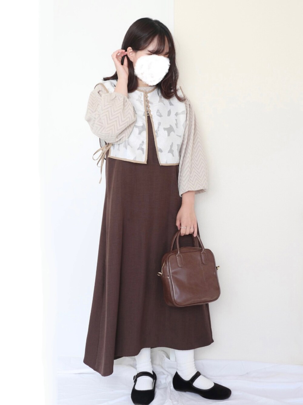 シルバー系のバッグ、ブラウン系のパンツ、ブラウン系のパンプスを着用したレディースの秋コーディネートの2枚目の写真