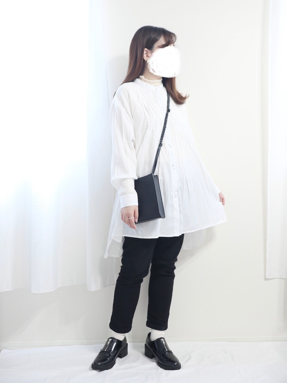 ホワイト系のブルゾン、ブラック系のショルダーバッグ、ホワイト系のシャツ/ブラウスを着用したレディースの冬コーディネートの2枚目の写真