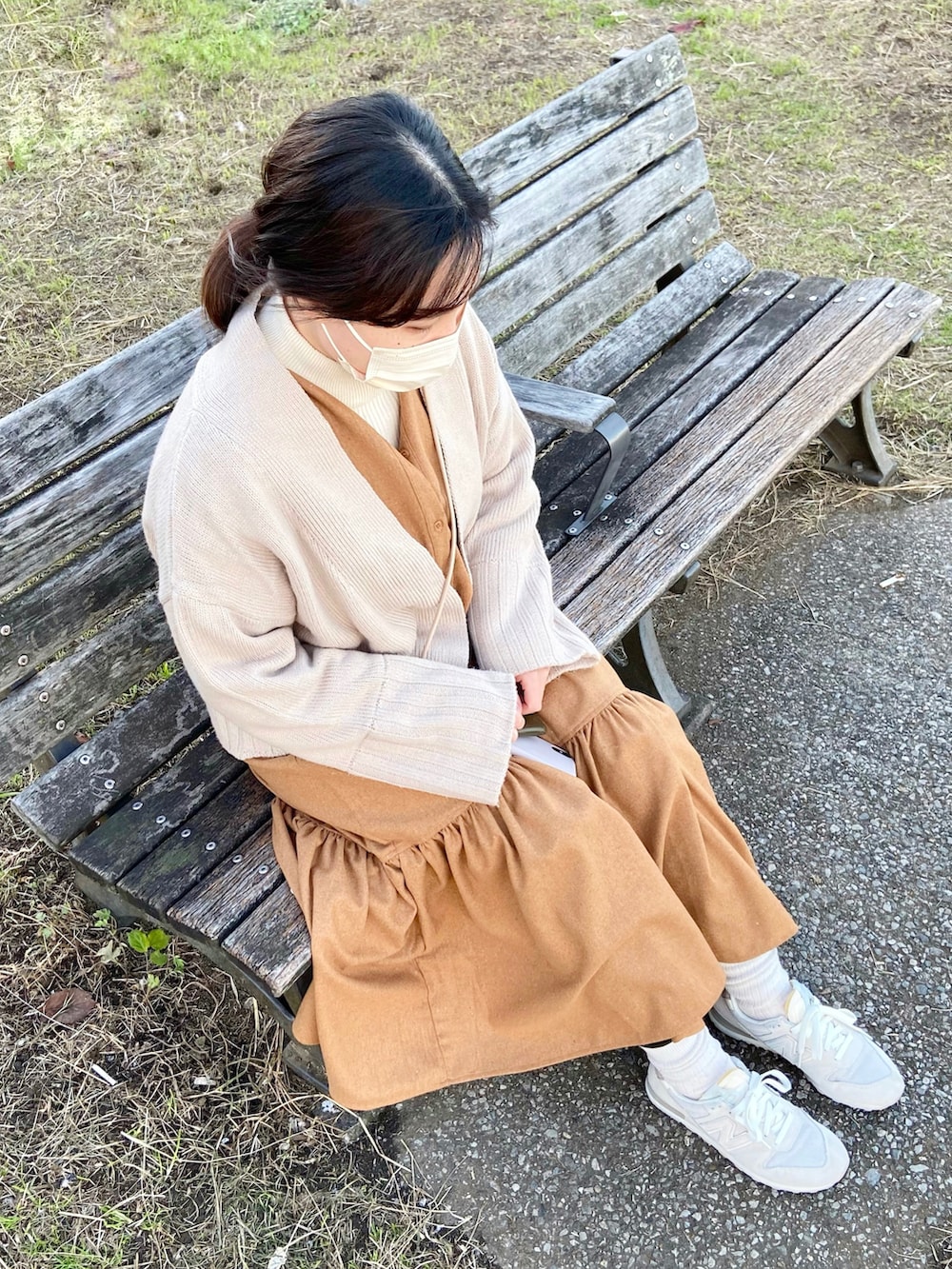 ベージュ系のワンピース、ベージュ系のカーディガン/ボレロ、ホワイト系のスニーカーを着用したレディースの冬コーディネートの2枚目の写真