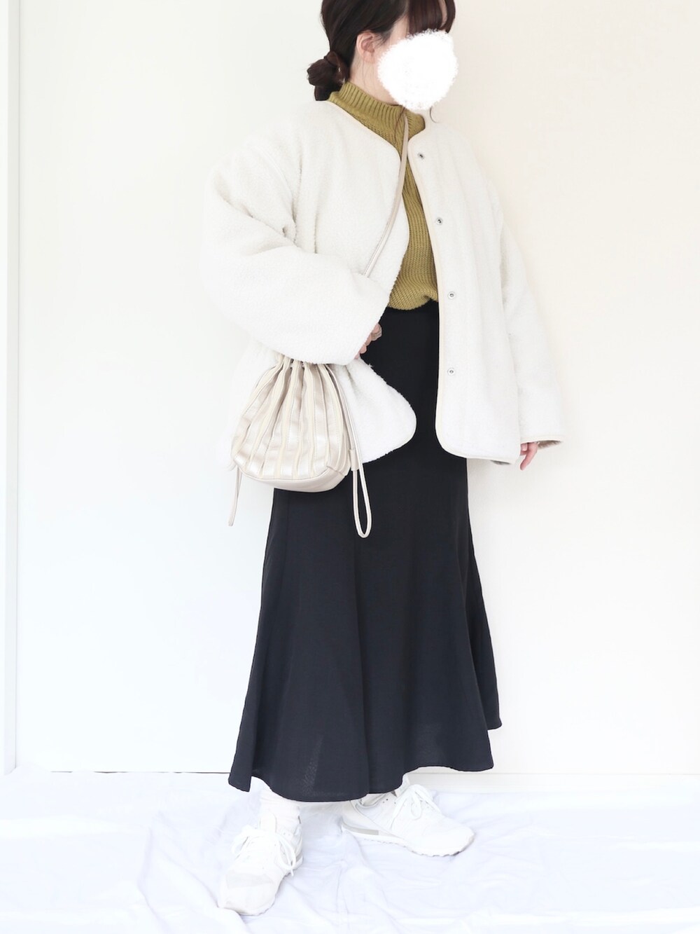 シルバー系のバッグ、ブラック系のスカート、ホワイト系のスニーカーを着用したレディースの秋コーディネートの2枚目の写真