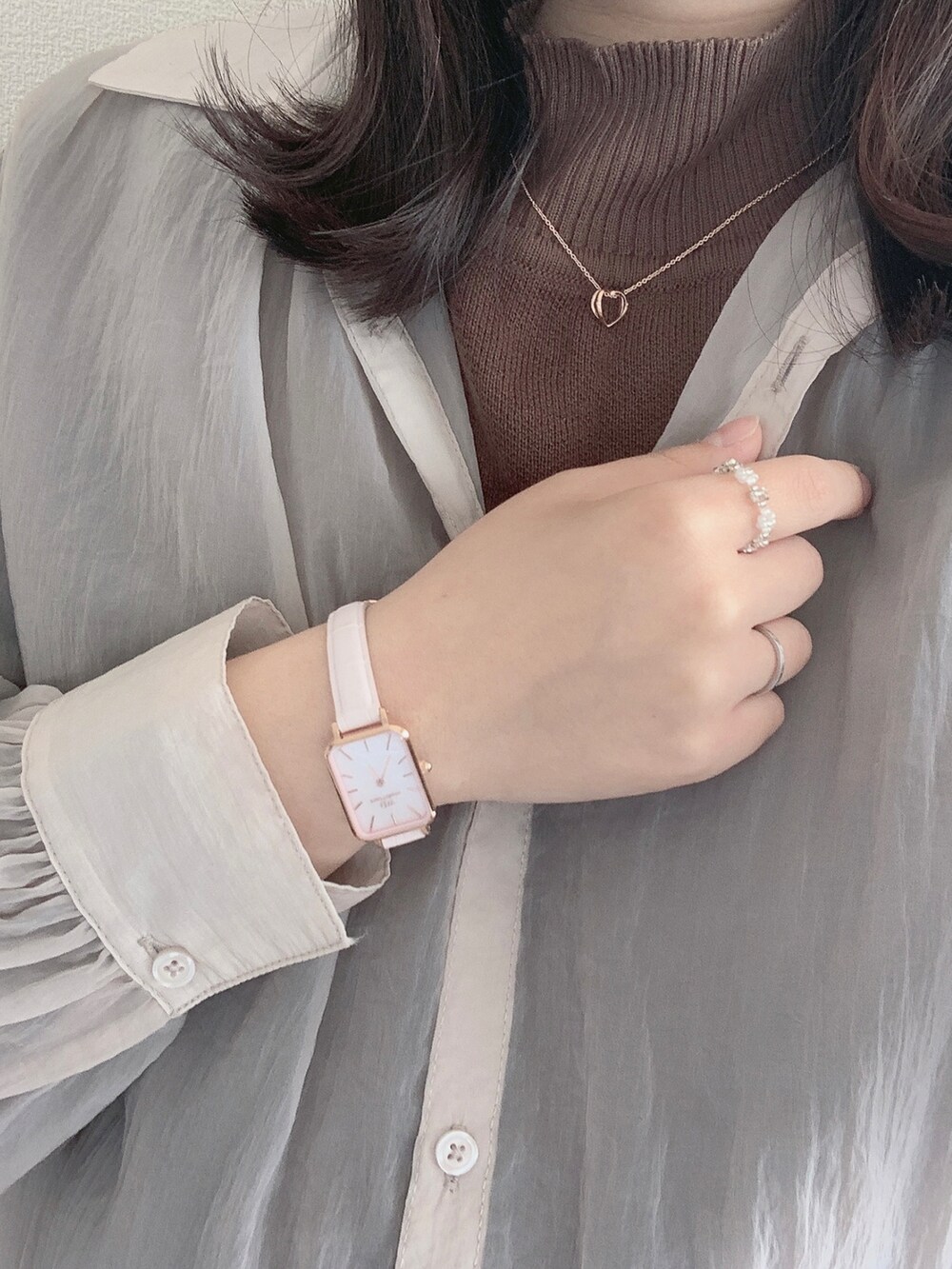 シルバー系のバッグ、ピンク系のシャツ/ブラウス、ブラウン系のパンツを着用したレディースの春コーディネートの3枚目の写真