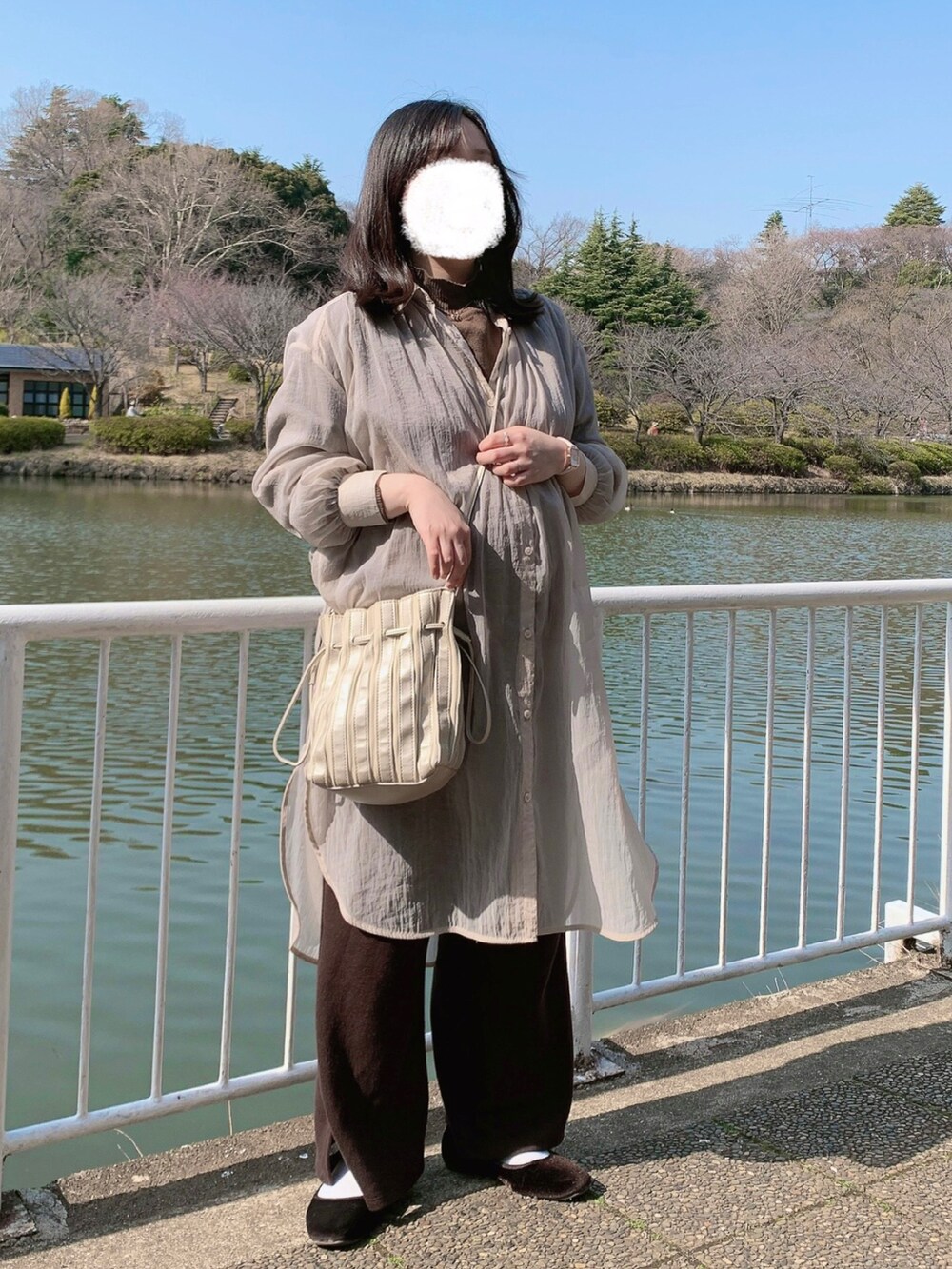 シルバー系のバッグ、ピンク系のシャツ/ブラウス、ブラウン系のパンツを着用したレディースの春コーディネートの2枚目の写真