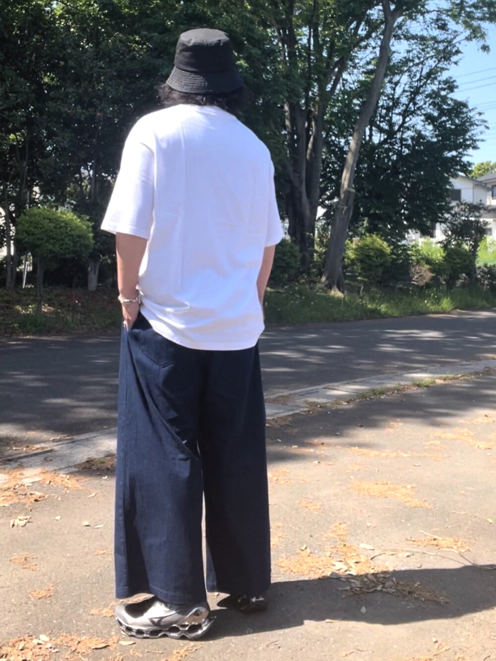 ホワイト系のTシャツ/カットソー、ブルー系のデニムパンツ、シルバー系のスニーカーを着用したメンズの春コーディネートの5枚目の写真