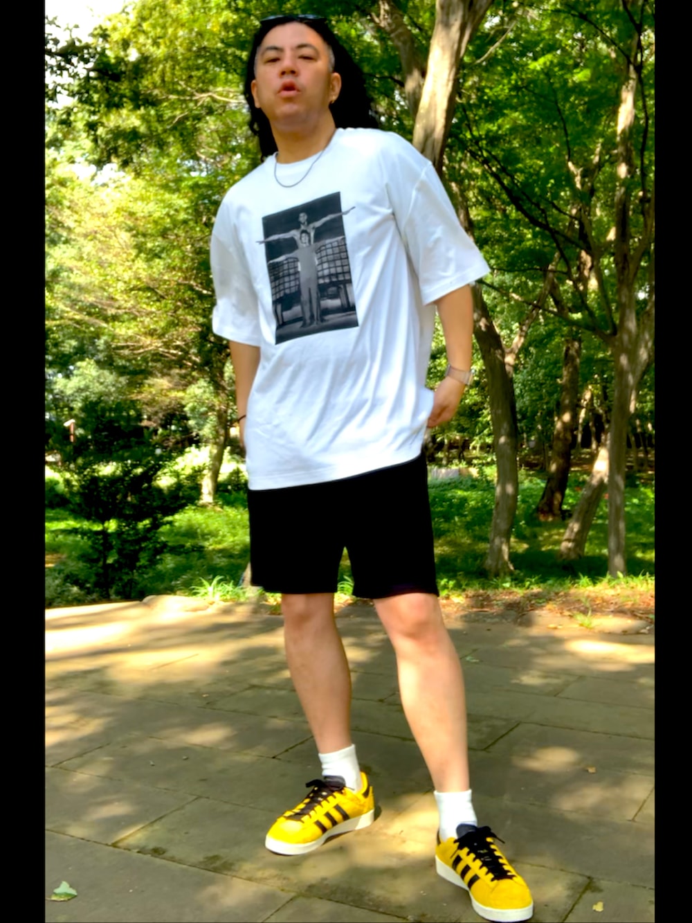 イエロー系のスニーカー、ブラック系のスウェットパンツ、ホワイト系のTシャツ/カットソーを着用したメンズの秋コーディネートの3枚目の写真