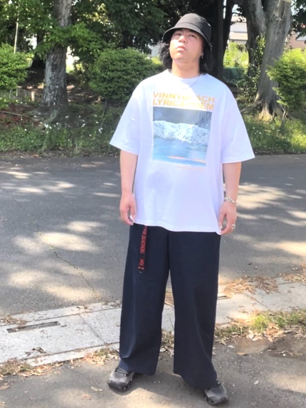 ホワイト系のTシャツ/カットソー、ブルー系のデニムパンツ、シルバー系のスニーカーを着用したメンズの春コーディネートの4枚目の写真