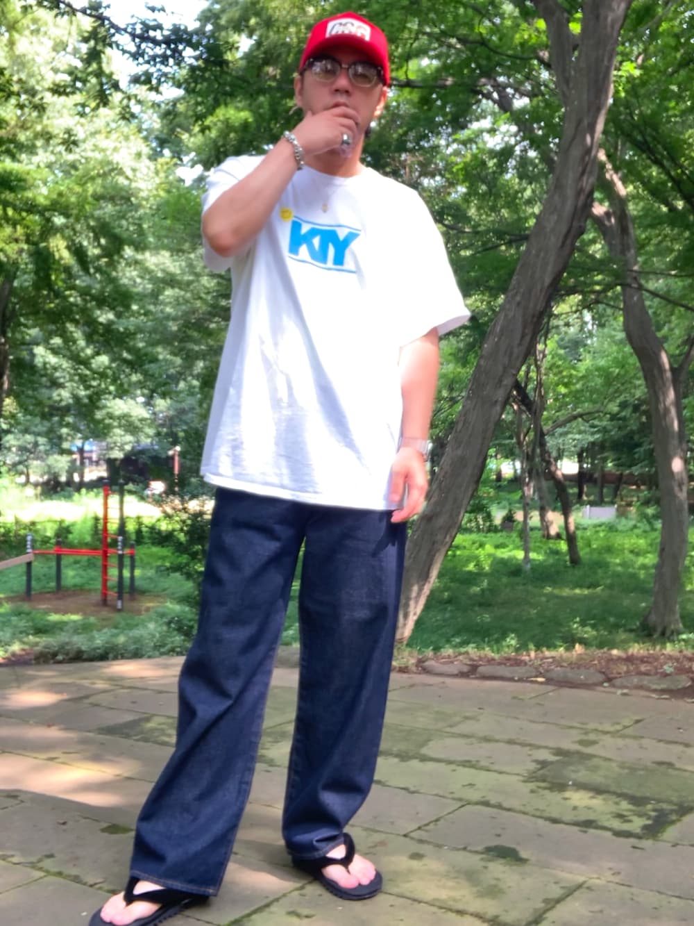 ホワイト系のTシャツ/カットソー、ブルー系のデニムパンツ、ブラック系のサンダルを着用したメンズの夏コーディネートの2枚目の写真