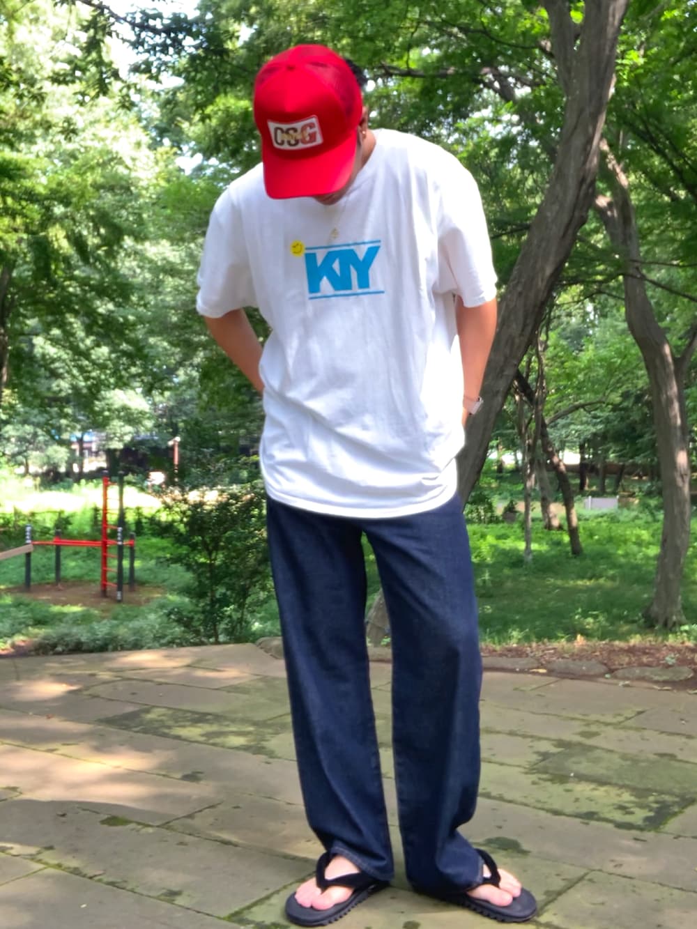 ホワイト系のTシャツ/カットソー、ブルー系のデニムパンツ、ブラック系のサンダルを着用したメンズの夏コーディネートの3枚目の写真