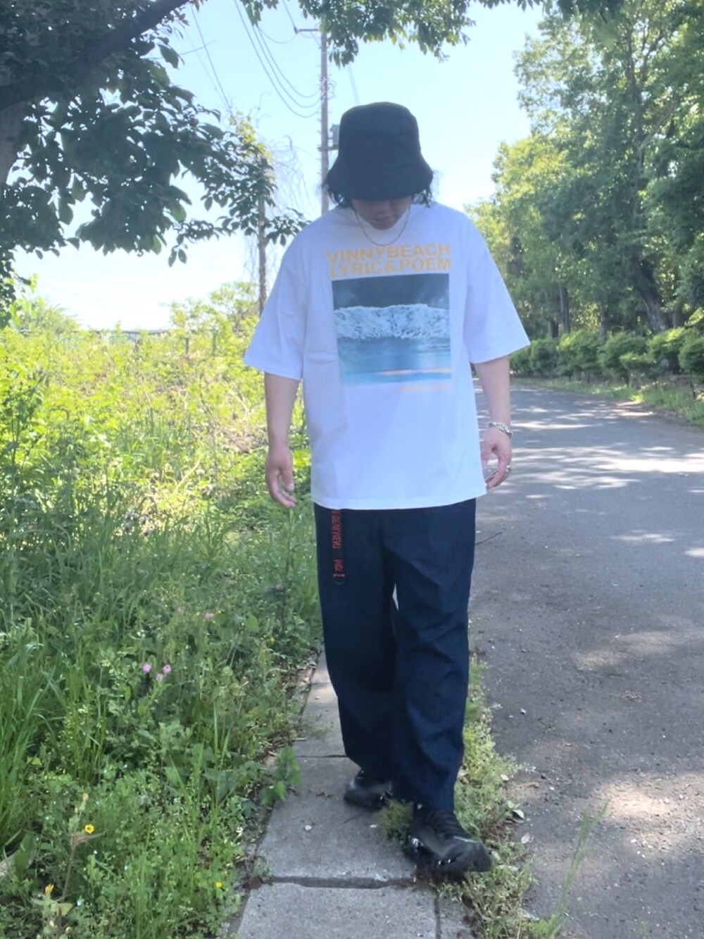 ホワイト系のTシャツ/カットソー、ブルー系のデニムパンツ、シルバー系のスニーカーを着用したメンズの春コーディネートの3枚目の写真