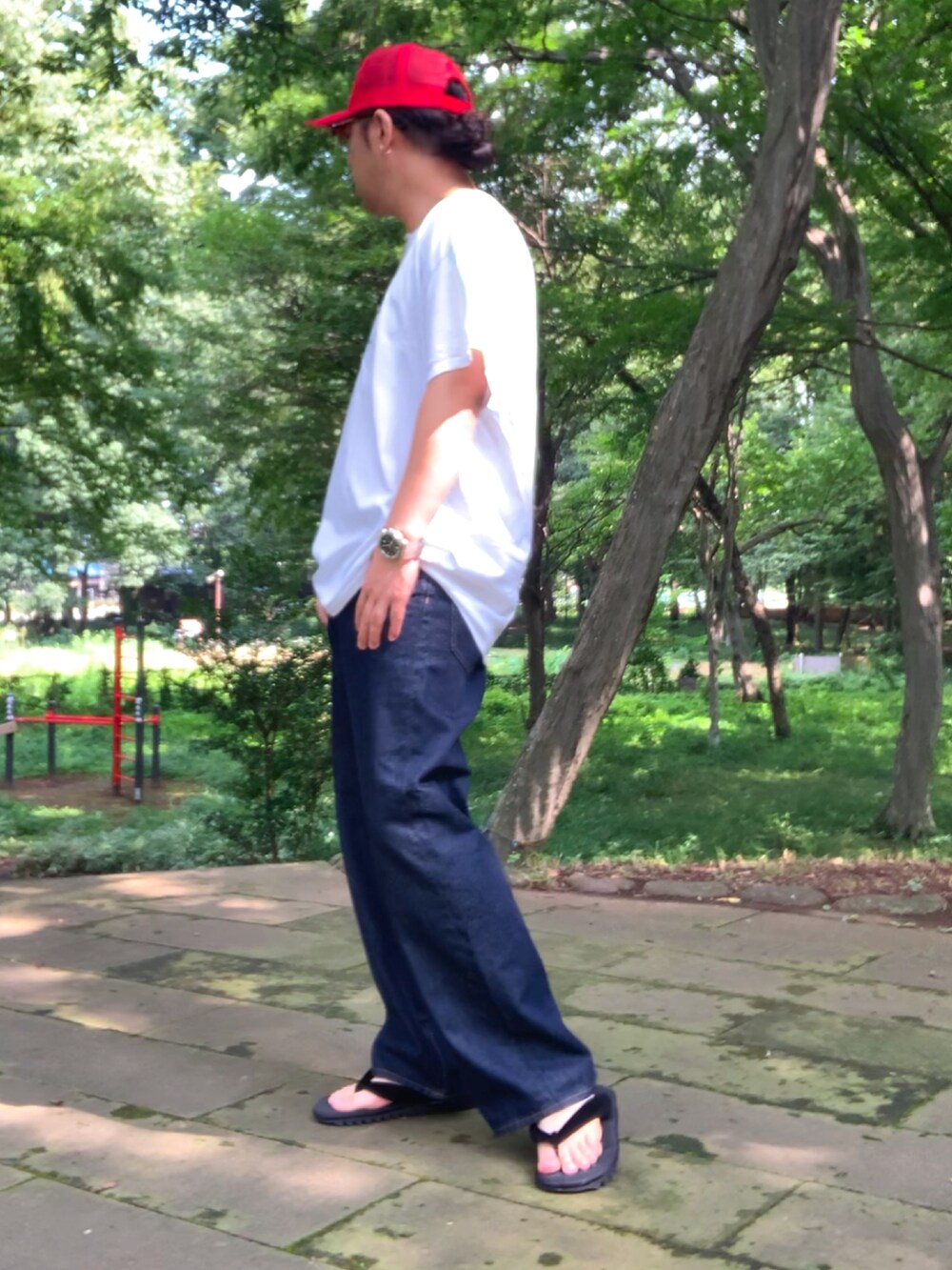 ホワイト系のTシャツ/カットソー、ブルー系のデニムパンツ、ブラック系のサンダルを着用したメンズの夏コーディネートの4枚目の写真