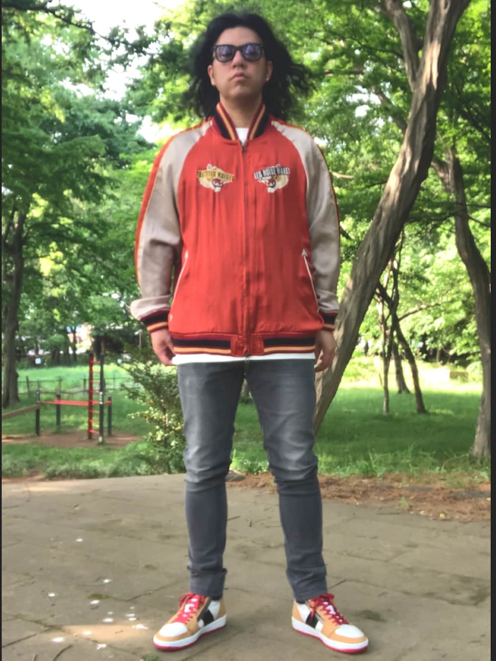 グレー系のデニムパンツ、ホワイト系のTシャツ/カットソー、レッド系のスカジャンを着用したメンズの春コーディネートの4枚目の写真