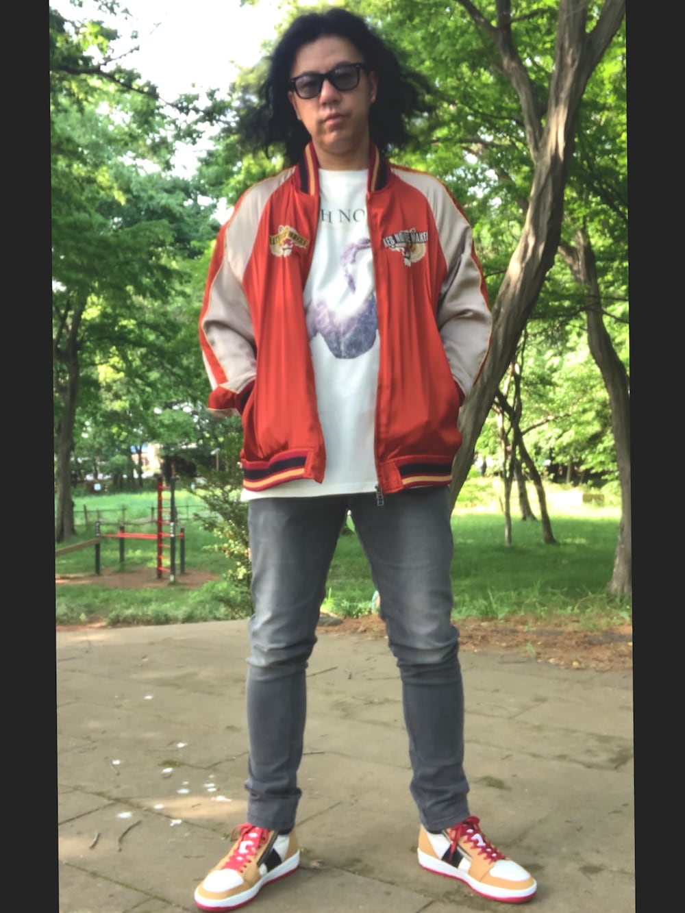 グレー系のデニムパンツ、ホワイト系のTシャツ/カットソー、レッド系のスカジャンを着用したメンズの春コーディネートの3枚目の写真