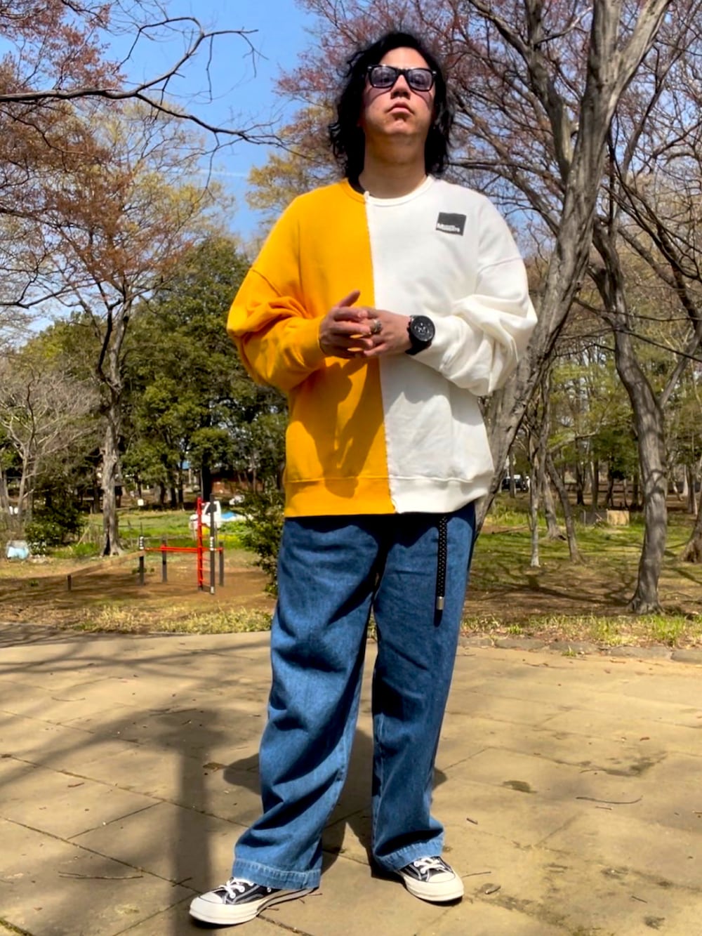 ブルー系のデニムパンツ、ブラック系のスニーカー、イエロー系のスウェットを着用したメンズの春コーディネートの2枚目の写真