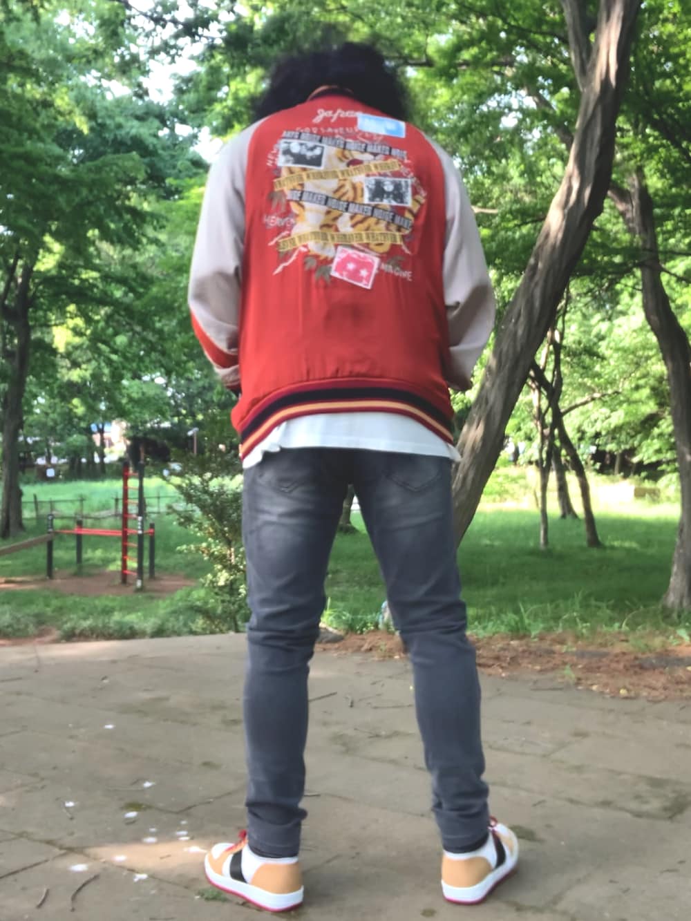 グレー系のデニムパンツ、ホワイト系のTシャツ/カットソー、レッド系のスカジャンを着用したメンズの春コーディネートの5枚目の写真