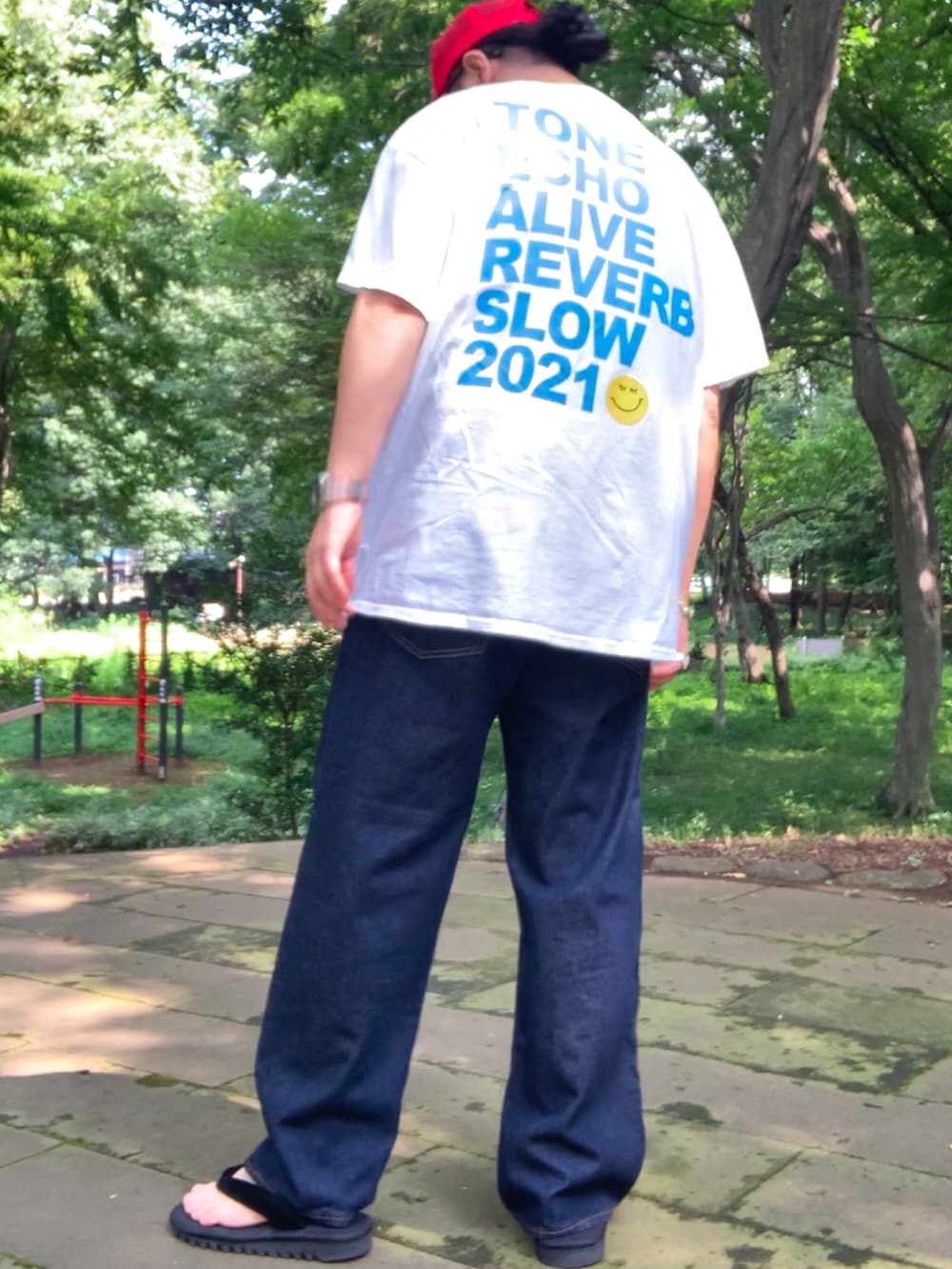 ホワイト系のTシャツ/カットソー、ブルー系のデニムパンツ、ブラック系のサンダルを着用したメンズの夏コーディネートの5枚目の写真